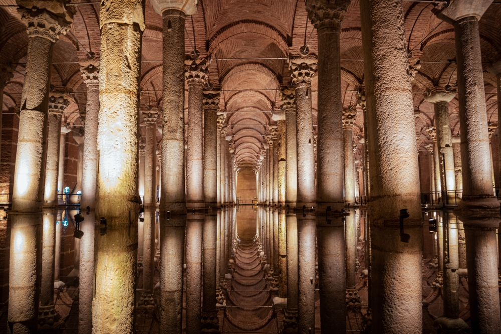 Interior de la Cisterna Basílica con filas de columnas antiguas y reflejos en el agua